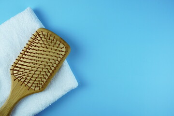 Wooden Comb and towel on blue background
