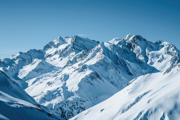 Fototapeta na wymiar Snow-covered mountain peaks against a clear blue sky in winter.