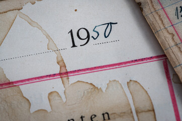 Closeup of vintage grungy, ledger paper with handwriting in ink and coffee stains. 
