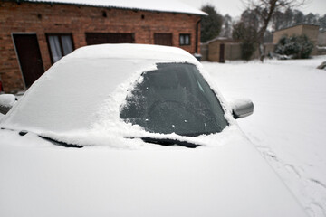 Frozen car windshield covered with ice and snow on a winter street day. Snow-covered car windshield at city.Close up view of the Front window of a car.