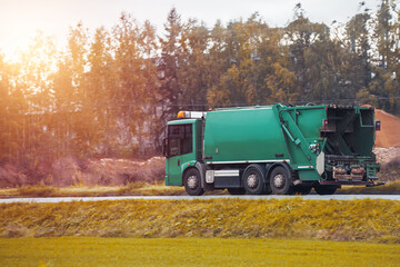 Recycling truck rides on the road in the suburbs. Garbage pickup truck. Concept of sorting garbage...
