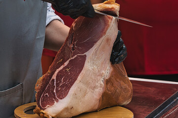 Butcher slicing a hamon in a shop