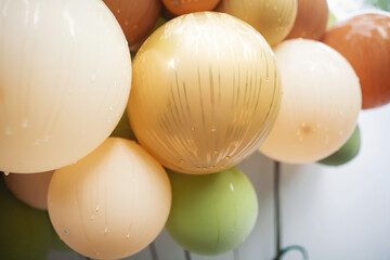 A closeup shot of balloons with dewdrops. Photo zone decoration from balloons on a baby party in a restaurant. lots of gray pink balloons on holiday. confetti birthday holiday celebration festive mood