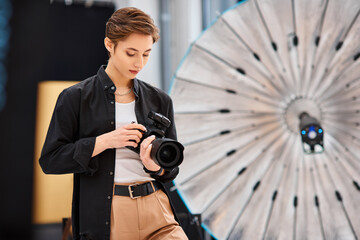 attractive young woman in casual attire taking photos with her modern camera in her studio