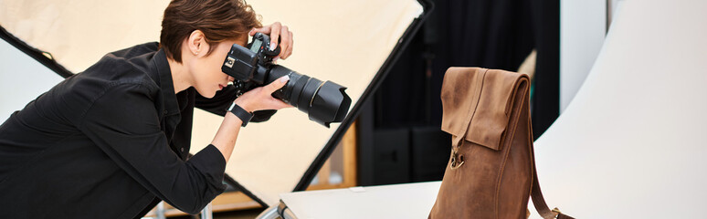 pretty female photographer taking photos of brown leathered backpack in her studio, banner - obrazy, fototapety, plakaty