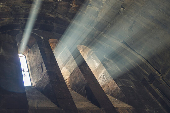 The sunlight shines through the narrow windows of the church