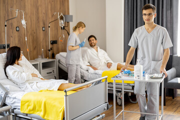 Nurses and patients in medical ward, nurse pushing cart with medications. Concept of nursing,...