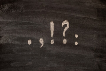 Punctuation marks written in chalk on a blackboard.