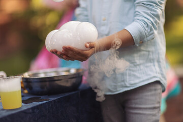 a bubble with steam in hands of a kid,science experiment. Nitrogen scientific experiments and show, shows for people and children. Chemical experiments. Foam and smoke after the experiments. Chemistry
