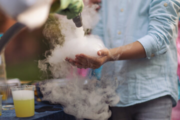 a bubble with steam in hands of a kid,science experiment. Nitrogen scientific experiments and show, shows for people and children. Chemical experiments. Foam and smoke after the experiments. Chemistry - obrazy, fototapety, plakaty