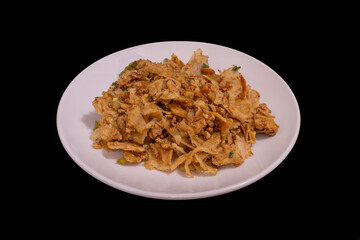 Sri Lankan kottu roti on a white plate against a black background