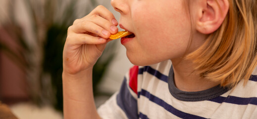 boy 10 years old eats chips close up, natural shot © Hanna