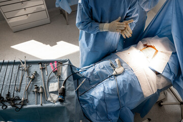 Surgery treatment in progress, view from above on medical tools and patient on operating table....