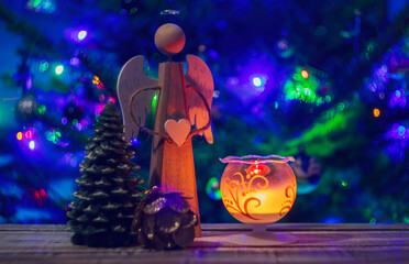 Wood angel, glass candle light, cone and christmas tree on wood table. Decoration background