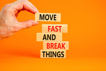 Move fast and break things symbol. Concept words Move fast and break things on wooden blocks. Beautiful orange background. Businessman hand. Business, move fast and break things concept. Copy space.