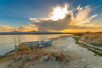 Fototapeta na wymiar Lone boat at sand beach at sunset. Lake Sevan, Armenia
