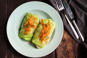 Cabbage rolls stuffed with meat on plate over green background. Top view, flat lay