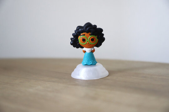 Mirabel Madrigal doll, protagonist of the Disney Pixar movie Encanto. Toy from the 100 years of Disney collection for the Macdonals Happy Meal. Isolated. Background with copy space. 