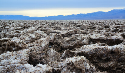 Death Valley National Park, Salt with clay, California. Smooth salt valley with cracked and swollen...