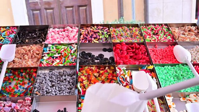 anonymous woman collects different types of gummy sweets from a stall at a village festival, gluttonous, jelly, sugar