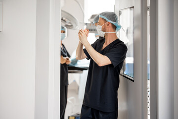 Surgeons entering door to an operation room before surgical treatment