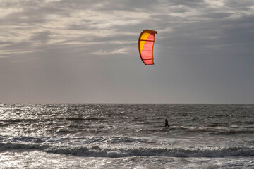 Silhouette of a person kitesurfing in the sea