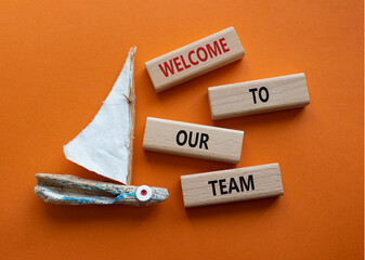 Welcome to our team symbol. Concept words Welcome to our team on wooden blocks. Beautiful orange...
