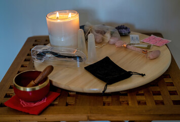 A plate with candle and acupuncture therapy related tools such as jade massager, medicine and stone...