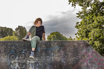 The girl is sitting on a concrete wall