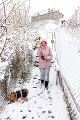 Woman with a dog walks outside in winter