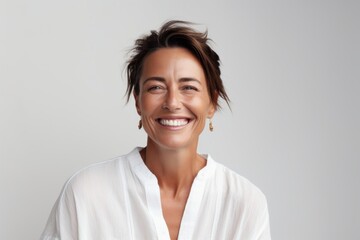 Fototapeta premium Portrait of a happy young woman smiling at camera against grey background