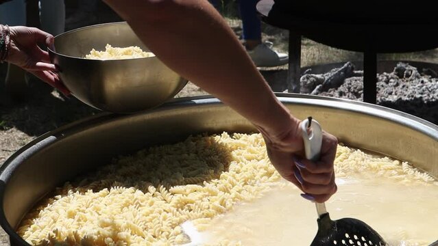 Tomato soup with pasta is a dish of Polish cuisine. Hot Zupa pomidorowa in a large cauldron at the field kitchen at a food fair. A popular soup made from grated tomatoes in their own juice.