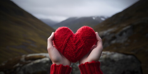 Red heart in hands against a mountain landscape. Love of nature, Valentine's Day, travel and adventure concept. - obrazy, fototapety, plakaty