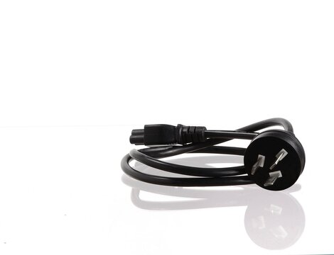 Black electrical plug with pins and cable on a white background.