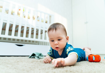 Baby Engaged in Playtime on the Floor. A baby laying on the floor playing with a toy