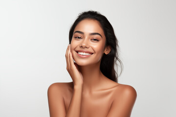 Beautiful happy young Indian woman touching her face caring for facial skin. Skincare concept