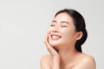Obraz na płótnie Canvas Beautiful happy young Asian woman touching her face caring for facial skin. Skincare concept