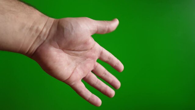 A man shows a "so-so" gesture with his hand on a green background. Slow motion