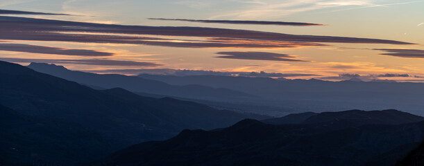 Sunset with spectacular lenticular clouds in the sky over the snowy peaks of Sierra Nevada (Granada, Spain)