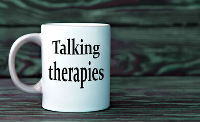 TALKING THERAPIES - the words on a white cup on a dark background.