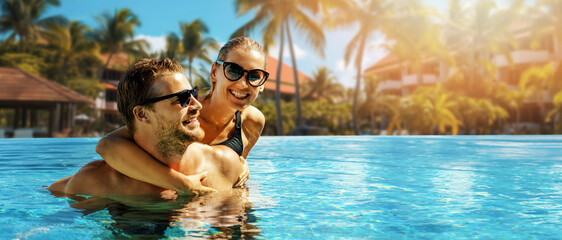 smiling happy couple having fun together in resort swimming pool. summer vacation, getaway travel. banner with copy space - obrazy, fototapety, plakaty