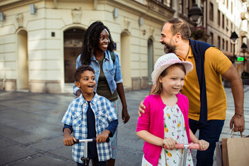 Multicultural Family Enjoying a Walk in the City Square - obrazy, fototapety, plakaty