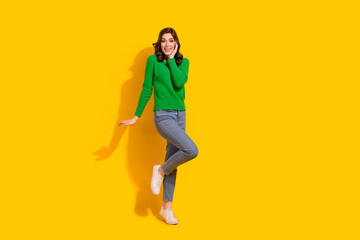 Fototapeta na wymiar Full length body photo of cute lady wear green pullover touch cheek celebrate shopping season start isolated on yellow color background