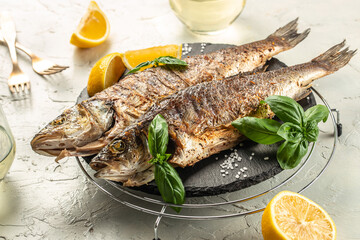 delicious grilled seabass fish with lemon and spices with white wine. banner, menu, recipe place...