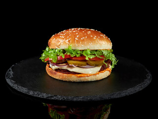 Close-up of a classic burger with meat and vegetables and sauce.