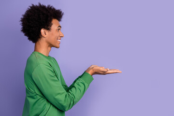 Photo of positive funky guy wear green pullover holding arms empty space isolated purple color background