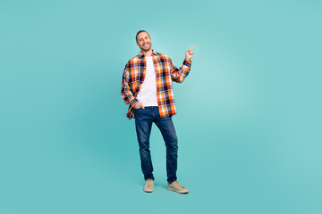 Full size photo of cool cheerful man dressed checkered shirt indicating at proposition empty space...