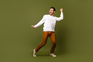 Photo of glad positive carefree man wear white trendy clothes look empty space isolated on khaki...