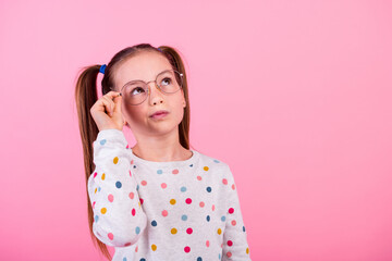 Portrait of minded smart schoolgirl dressed dotted pullover touching eyewear look at offer empty...