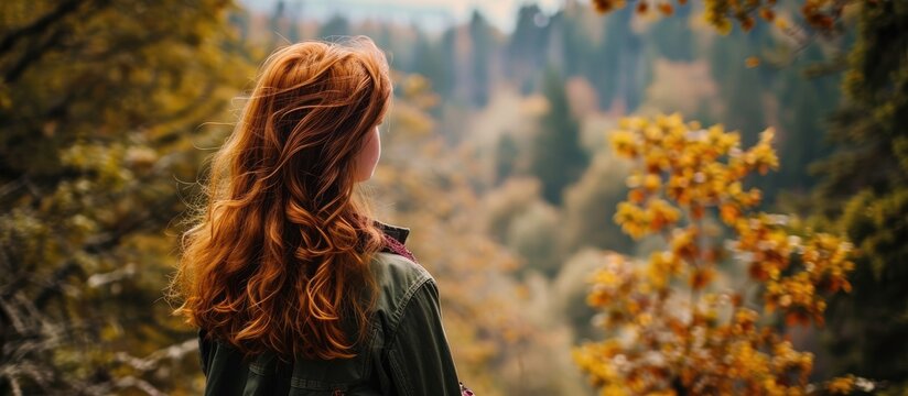 A red-haired woman admires the forest view in a high-quality photo.